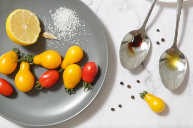 Yaz salatası malzemeleri - Taze toplanmış kiraz domatesleri, bir kaşık sirke ve zeytinyağı, tuz ve biber