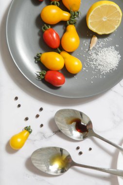 Yaz salatası malzemeleri - Taze toplanmış kiraz domatesleri, bir kaşık sirke ve zeytinyağı, tuz ve biber