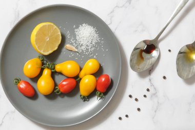 Yaz salatası malzemeleri - Taze toplanmış kiraz domatesleri, bir kaşık sirke ve zeytinyağı, tuz ve biber