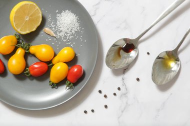 Yaz salatası malzemeleri - Taze toplanmış kiraz domatesleri, bir kaşık sirke ve zeytinyağı, tuz ve biber