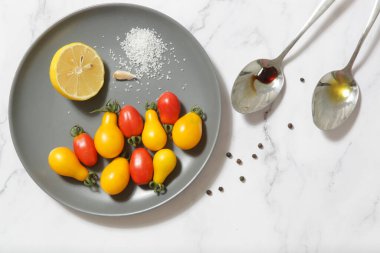 Yaz salatası malzemeleri - Taze toplanmış kiraz domatesleri, bir kaşık sirke ve zeytinyağı, tuz ve biber