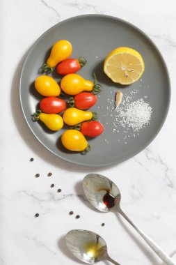Yaz salatası malzemeleri - Taze toplanmış kiraz domatesleri, bir kaşık sirke ve zeytinyağı, tuz ve biber