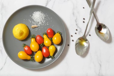 Yaz salatası malzemeleri - Taze toplanmış kiraz domatesleri, bir kaşık sirke ve zeytinyağı, tuz ve biber