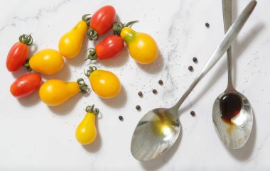 Yaz salatası malzemeleri - Taze toplanmış kiraz domatesleri, bir kaşık sirke ve zeytinyağı, tuz ve biber