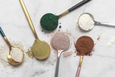 Sağlık ve güzellik için farklı beslenme malzemeleri - kolajen, vitamin, biyotin, kaşıklardaki protein tozu