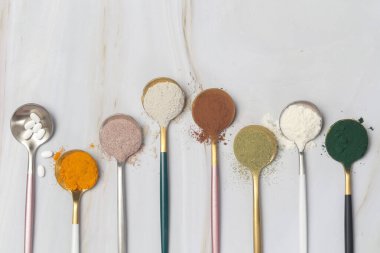 Sağlık ve güzellik için farklı beslenme malzemeleri - kolajen, vitamin, biyotin, kaşıklardaki protein tozu