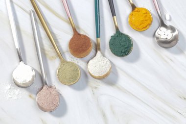 Sağlık ve güzellik için farklı beslenme malzemeleri - kolajen, vitamin, biyotin, kaşıklardaki protein tozu