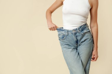 Sonra diyet büyük kot giyen genç bir beyaz uygun kadın stüdyo çekim