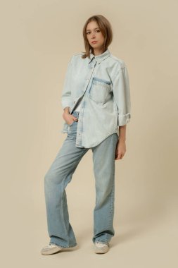 Modern gündelik kıyafet, kot pantolon, beyaz atlet ve kot tişört giymiş bir kadının seri fotoğrafları..