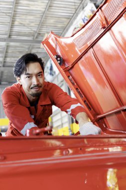 Servis istasyonunda çalışan profesyonel araba tamircisi. Araç tamir ediliyor. Otomobil Salonu 'ndaki Üniformalı Araç Motoru. Seçici Odaklanma