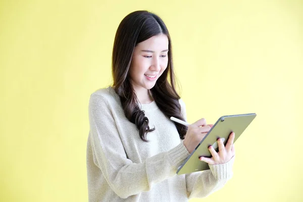 Jovem Mulher Asiática Usando Tablet Digital Enquanto Sobre Fundo Amarelo — Fotografia de Stock
