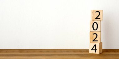 Ahşap blok ve beyaz beton duvarlı yeni yılınız kutlu olsun. Fotokopi arkaplanı, mutlu yıllar 2024 tebrik kartı, afiş.