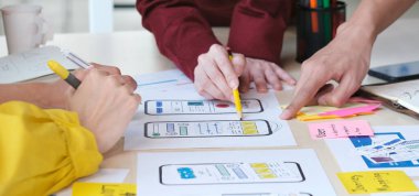Beyin fırtınası planlama, yaratıcı takım çalışması, akıllı telefon, ui, ux konsepti için ekran görüntüleme prototipi planıyla ilgili elleri cep telefonu uygulaması geliştirici ekip toplantısı.