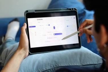 Zaman çizelgesi çizelgesi olan dijital tablet tutan adam, çalışma planı yönetimi