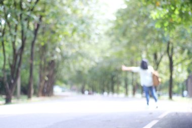 Sırt çantalı bulanık bir kadın otostop çekiyor kırsal alanda, seyahat konsepti