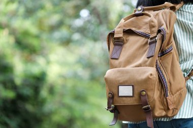 Sırt çantası gezgini, metin, seyahat ve yaşam tarzı konsepti için kopyalama alanı olan yeşil ağaç doğa arka planına yakın plan