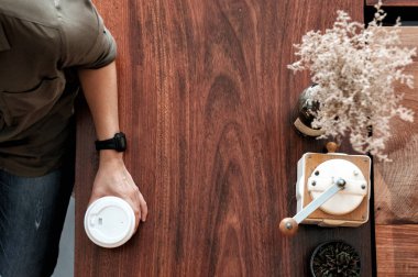 El ele tutuşup kahve fincanını al, kafenin arkasındaki ahşap masaya koy, fotokopi alanının olduğu üst manzara.