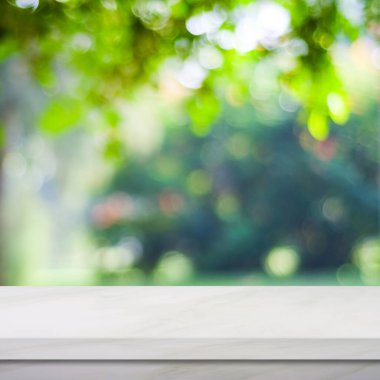 Bulanık yeşil park arkaplanı üzerine boş beyaz mermer tablo, ürün ekran montajı