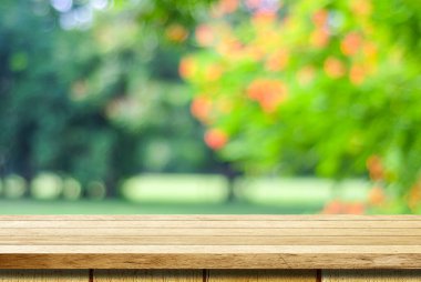 Boş ahşap masa ile ürün görüntü montajı için bokeh arka plan bulanık ağaç üzerinde