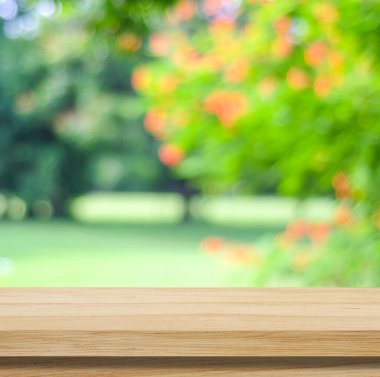 Boş ahşap masa ile ürün görüntü montajı için bokeh arka plan bulanık ağaç üzerinde