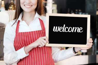 Kafe arka planında hoş geldin tabelası tutan kadınlar, küçük işletme sahibi, yiyecek ve içecek endüstrisi konsepti