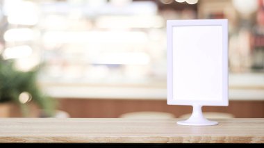 Boş beyaz menü tahtası bulanık restoranın üzerinde duruyor. Arka plan bokeh, metin için alan, maket, ürün ekran montajı, pankart