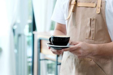 Kafede kahve servisi yapan erkek barista, yiyecek ve içecek servisi kavramı.
