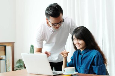 Genç Asyalı erkek ve kadın bilgisayar ekranını günlük yaşam tarzı, teknoloji ve yaşam tarzında kullanıyor ve işaret ediyor.