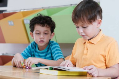 Anaokulu sınıflarında kitap okuyan çocuklar, çocuk eğitimi kavramı