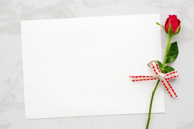Sevgililer günü arka plan, şablon, kopya alanı metin, üstten görünüm, düz lay için beyaz mermer zemin üzerine kırmızı gül ve boş beyaz kağıt