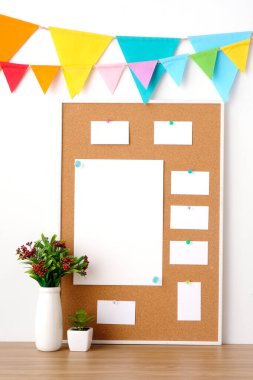 Mantar panoda asılı renkli parti bayrakları, tahta masa arkasında boş not kağıtları, doğum günü, yıldönümü, kutlama etkinliği, festival geçmişi