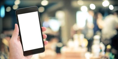 El ele tutuşan akıllı telefon, ekranda boş, restoranın arka planında, modelle, şablonla, restoran rezervasyonuyla, internetteki yemeklerle, yemek dağıtım konseptiyle.