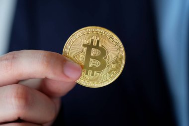 İş adamı elinde bitcoin, kripto para ve engelleme zinciri konsepti tutuyor.