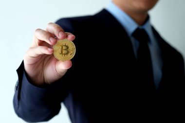 İş adamı elinde bitcoin, kripto para ve engelleme zinciri konsepti tutuyor.