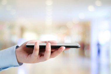 İş adamı, metin için kopyalama alanı, telefon, teknoloji ve yaşam tarzı olan bulanık ofis arka planında akıllı telefon kullanıyor.