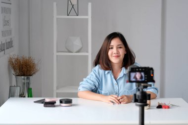 Genç Asyalı kadın güzellik blogcusu video eğitimi, vlog konsepti, insan ve teknoloji iletişimini nasıl oluşturacağını gösteriyor