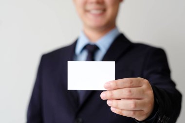 İş adamı elinde metin için fotokopi alanı olan boş bir beyaz kartvizit tutuyor. İş dünyası arka plan konseptini oluşturuyor. 