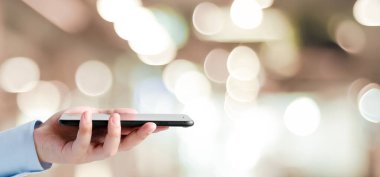 El bulanıklık bokeh ışık arka plan, iş ve teknoloji, nesnelerin interneti kavramı üzerinde akıllı telefon kullanarak