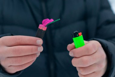 Guy kışın açık havada Flash Gürültülü Havai Fişek 'i ateşe veriyor. Gürültülü ve tehlikeli yeni yıl eğlencesi. Havai fişeklerle holiganlık. Halka Açık Yerlerdeki Petard 'ların Gürültüsü