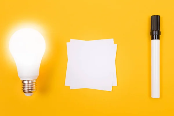 Leuchtende Energiesparlampe Mit Weißem Notizpapier Auf Gelbem Tisch Liegend Leere — Stockfoto