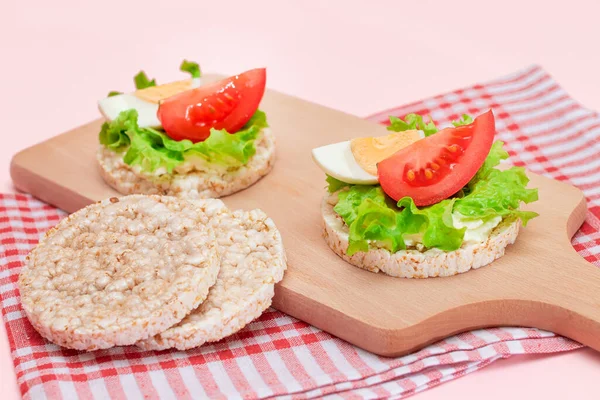 Rice Cake Sandwiches with Tomato, Lettuce and Egg on Wooden Cutting Board. Easy Breakfast. Diet Food. Quick and Healthy Sandwiches. Crispbread with Tasty Filling. Healthy Dietary Snack