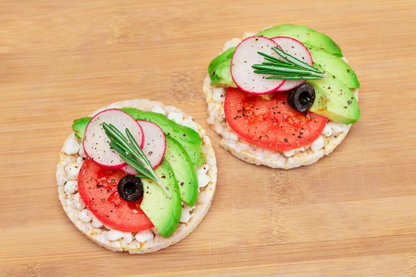 Rice Cake Sandwiches with Avocado, Tomato, Cottage Cheese, Olives and Radish on Bamboo Cutting Board. Easy Breakfast. Diet Food. Quick and Healthy Sandwiches. Crispbread with Tasty Filling