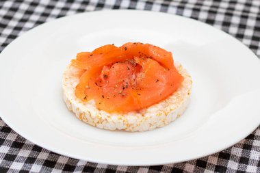 Tasty Rice Cake Sandwich with Fresh Salmon Slices on White Plate. Easy Breakfast and Diet Food. Crispbread with Red Fish. Healthy Dietary Snack