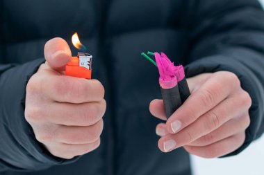 Adam kışın açık havada Flash Gürültülü Havai fişekleri ateşe veriyor. Gürültülü ve tehlikeli yeni yıl eğlencesi. Havai fişeklerle holiganlık. Halka Açık Yerlerdeki Petard 'ların Gürültüsü