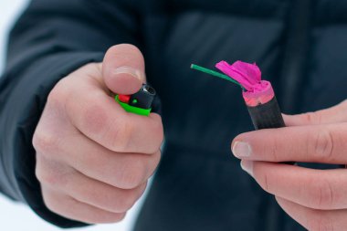 Guy kışın açık havada Flash Gürültülü Havai Fişek 'i ateşe veriyor. Gürültülü ve tehlikeli yeni yıl eğlencesi. Havai fişeklerle holiganlık. Halka Açık Yerlerdeki Petard 'ların Gürültüsü
