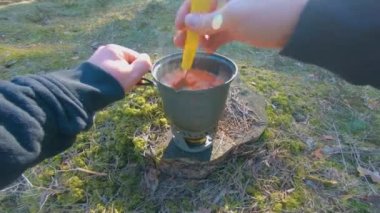 Camp Food. Cooking in a Hike Using a Small Cook Set - First Person View, Wide Angle. Food on the Trip. Traveler in a Spring Forest. Tourist in a Travel is Heating Food - POV Shot.
