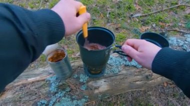 Camp Food. Cooking in a Hike Using a Small Cook Set - First Person View, Wide Angle. Food on the Trip. Traveler in a Spring Forest. Tourist in a Travel is Heating Food - POV Shot.