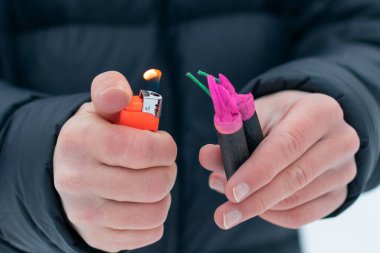 Adam kışın açık havada Flash Gürültülü Havai fişekleri ateşe veriyor. Gürültülü ve tehlikeli yeni yıl eğlencesi. Havai fişeklerle holiganlık. Halka Açık Yerlerdeki Petard 'ların Gürültüsü