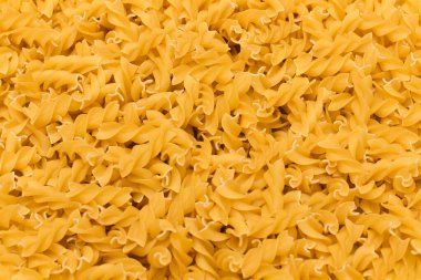 Çözülmemiş Fusilli Makarnası - Arka plan. Parlak Altın Kuru Makarna