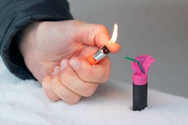 Guy kışın açık havada Flash Gürültülü Havai Fişek 'i ateşe veriyor. Gürültülü ve tehlikeli yeni yıl eğlencesi. Havai fişeklerle holiganlık. Halka Açık Yerlerdeki Petard 'ların Gürültüsü